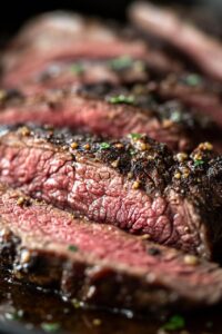 Close-up of juicy, sliced chuck roast cooked to perfection, seasoned with herbs and spices.