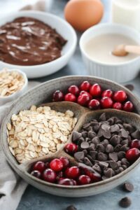  Ingredients for chocolate cranberry oat muffins, including oats, cranberries, chocolate chips, and other baking essentials.